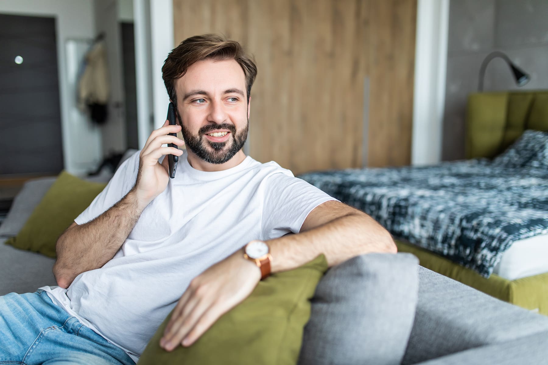 A man sitting on the couch waiting for a free consulation for a harir relpacement in Reno